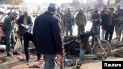 An Afghan police officer stands at the site of a bomb blast in Faryab, March 18, 2014.