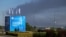 Pillars of smoke rise into the sky above Russia's St. Petersburg on June 3, behind a banner advertising the city's 29th International Economic Forum.