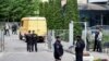 Российские правоохранители собираются у многоэтажного дома в Москве после сообщения об атаке беспилотника. 30 мая 2023 года