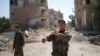 A Kurdish fighter from the People's Protection Units (YPG) gestures in Raqqa, Syria.