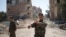 A Kurdish fighter from the People's Protection Units (YPG) gestures in Raqqa, Syria.