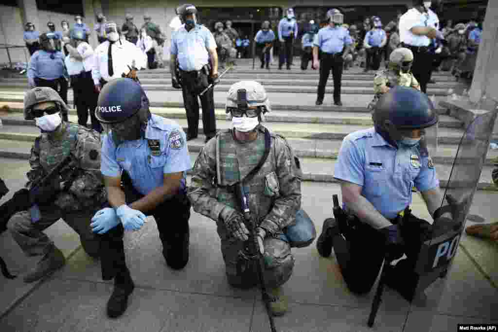 После призыва Мелвина Синглетона полицейские и военнослужащие Национальной гвардии опустились на колено. Филадельфия, 1 июня 2020 года.