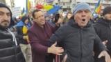 Un bărbat încearcă să liniștească un manifestant care huiduie o echipă de jurnaliști la protestul AUR, pe 12 ianuarie 2025.