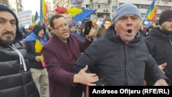 Un bărbat încearcă să liniștească un manifestant care huiduie o echipă de jurnaliști la protestul AUR, pe 12 ianuarie 2025.