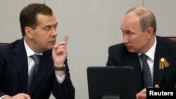 Could a generation gap be emerging in the Kremlin with a disconnect between older cronies of President Vladimir Putin (right) and younger individuals linked with Prime Minister Dmitry Medvedev? 