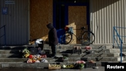A woman sells vegetables on the steps of a closed supermarket amid Russia's attack on Ukraine in Pokrovsk in Ukraine's eastern Donetsk region on October 28.