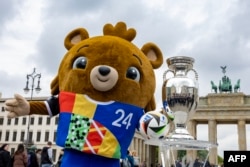 Медвежонок Альберт, официальный талисман Евро-2024, позирует в центре Берлина на фоне кубка, который будет вручен команде – победительнице турнира