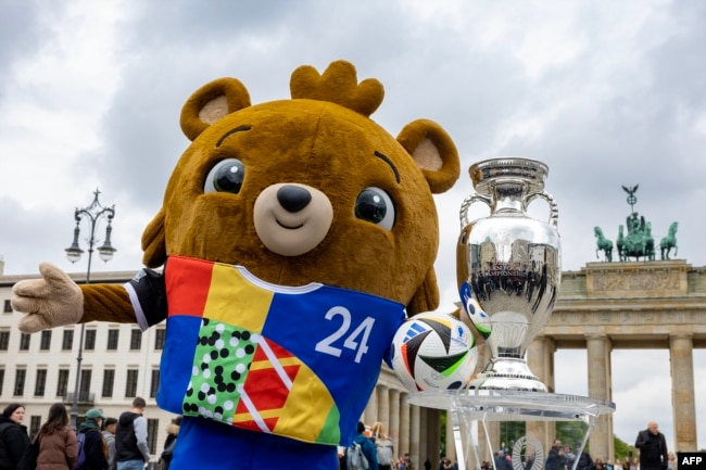 Медвежонок Альберт, официальный талисман Евро-2024, позирует в центре Берлина на фоне кубка, который будет вручен команде – победительнице турнира