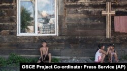 Roma children rest in the shade of a church wall inside an encampment on the outskirts of Uzhhorod in western Ukraine. (file photo)