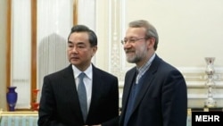 Зустріч спікера іранського парламенту Алі Ларіджані (п) з міністром закордонних справ Китаю Ван І, Тегеран, 27 березня 2021 року