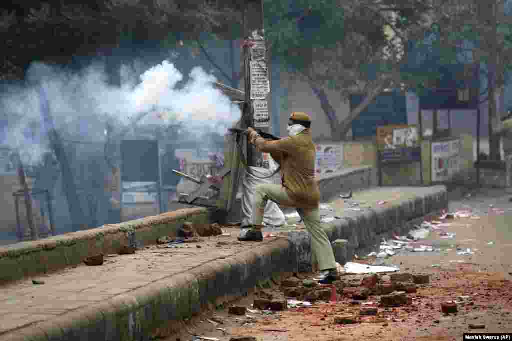 A policeman fires teargas during a protest in the Seelampur area of New Delhi on December 17.