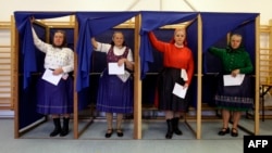 Femei în costume tradiționale maghiare la o secție de votare din Veresegyhaz, la aproximativ 30 km est de Budapesta.