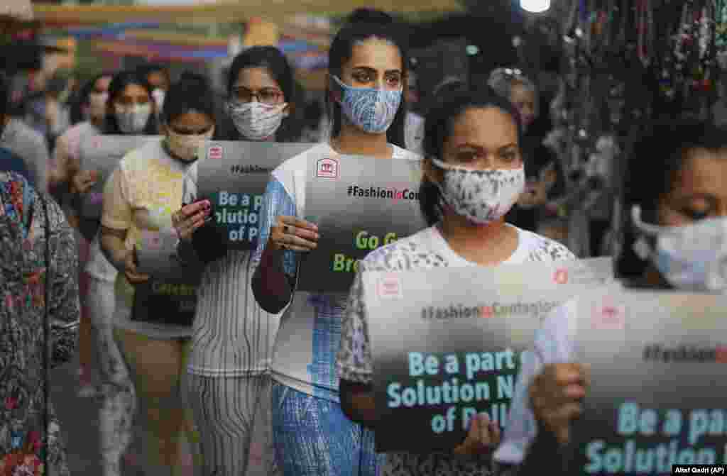 Indian fashion students, wearing antipollution masks, hold placards as they march through a marketplace to create awareness of air pollution in New Delhi. With air quality reduced to &quot;very severe&quot; in the Indian capital region, authorities are bracing for a major Hindu festival featuring massive fireworks that threatens to cloak New Delhi with more toxic smog and dust. (AP/Altaf Qadri)