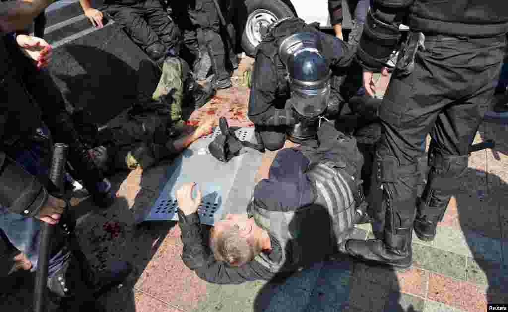 При столкновениях в августе 2015 году у здание Верховной Рады в Киеве офицеры национальной гвардии совместно с полицейскими помогают раненым