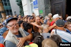 Az emberek pénzsegélyért állnak sorba az orosz erők által ellenőrzött Herszonban