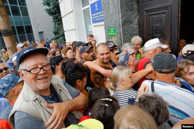 Люди в очереди за финансовой помощью в Херсоне, контролируемом российскими войсками