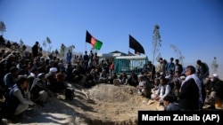 Afghan men bury a victim of the October 24 suicide attack that targeted an education center in Kabul.