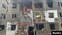 Ратавальнік тушыць пажар у шматпавярховіку пасьля атакі дронаў. Чарнігаў, 25 сьнежня 2025