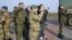 OSCE military observers take photos during negotiations with pro-Russian forces at a checkpoint blocking the entrance to Crimea last month.