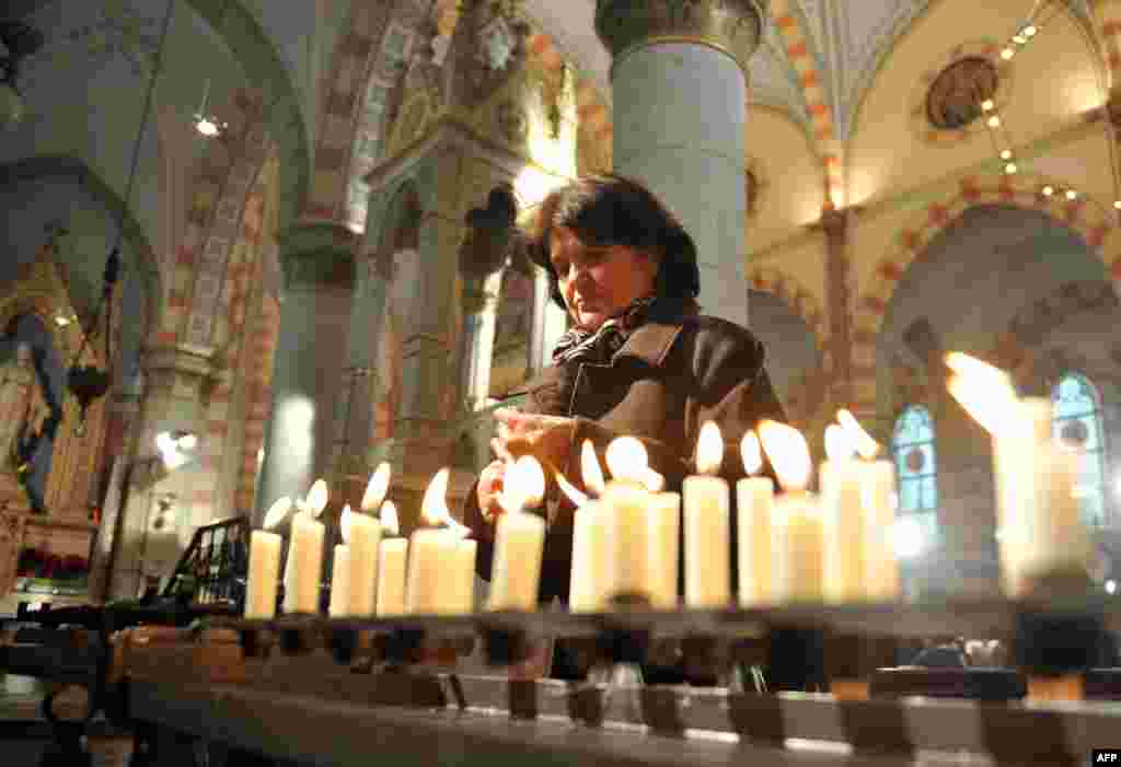 Bosnia-Herţegovina - O croată bosniacă aprinde lum&acirc;nări după slujba de Crăciun la catedrala &quot;Inima lui Isus&quot; din Sarajevo. 25 decembrie 2012. (AFP/Elvis Barukcic)