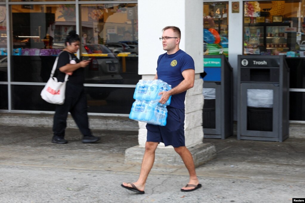 Një burrë nxjerr paketa me ujë të ambalazhuar nga një dyqan pas paralajmërimeve të autoriteteve për një cunam të mundshëm, në Honolulu, Havai, SHBA, më 29 korrik 2025.