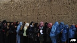 مهاجرین برگشته به کشور هنگام اخذ کمک های "یو ان اچ سی آر" صف بسته اند