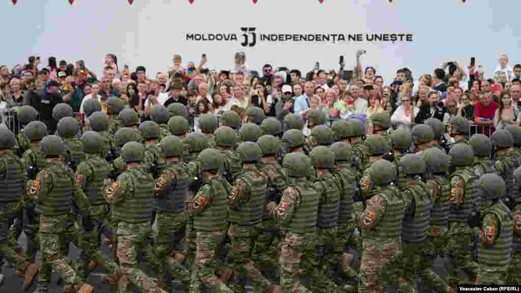 Un detașament de militari moldoveni trece pe lângă publicul venit la paradă. „Moldova 35: Independența care ne unește” este sloganul Zilei Independenței.