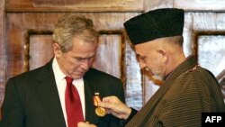 Afghan President Karzai (right) presents President Bush with a medal in Kabul.