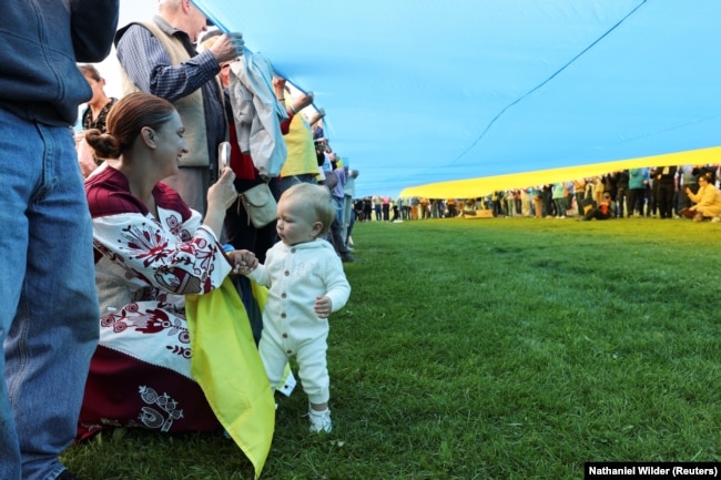 Un mare steag al Ucrainei a fost întins de demonstranți în Anchorage, Alaska, SUA, pe 15 august 2025, înaintea summitului Putin-Trump.