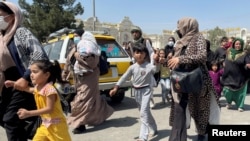 Жени се опитват да влязат заедно с децата си на летището в Кабул, 16 август 2021.