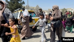 Afghans try to get into the airport in Kabul on August 16, in an attempt to escape Taliban rule.