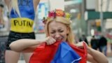 Inna Șevcenko sfîșie un drapel rusesc la un protest Femen împotriva intervenției rusești în Ucraina și în sprijinul sancțiunilor anunțate de America, Times Square, New York, 6 martie 2014.