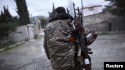 Armenia - A soldier of the self-defense army of Nagorno-Karabakh carries weapons in Martakert district, April 4, 2016