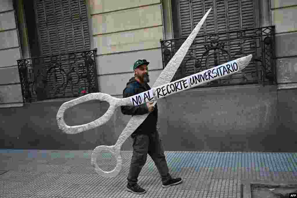 Demonstrant nosi džinovske makaze sa natpisom na španskom &quot;Ne rezovima univerziteta&quot;, u Buenos Airesu, Argentina, 2. oktobra.