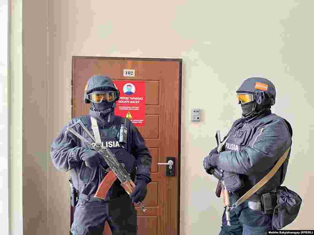 Қарулы полиция қызметкерлері Orda.kz басылымы редакциясының есігін күзетіп тұр. Бұл күні "Көрінеу жалған ақпарат тарату" бабымен күдікке ілінген басылымның редакциясы және бас редакторы Гүлнәр Бажкенованың үйінде тінту жүргізілді. Кейін Бажкенова үйқамаққа алынды. Артында дәл осындай айып ҚазТАГ ақпарат агенттігінің басшылығына да тағылып, бас редактор Әмір Қасенов үйқамаққа алынды.Алматы, 1 желтоқсан, 2025 жыл.Фото авторы: Мейірім Бақытжан, Азаттықтың Қазақ қызметі.  