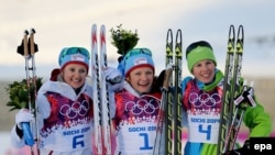 Norway's Maiken Caspersen Falla (center) celebrates winning the gold medal next to silver medalist Ingvild Flugstad Oestberg (left) of Norway and bronze medalist Vesna Fabjan (right) of Slovenia after the women's cross-country freestyle sprint race on February 11. 