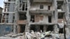 A resident of a Kyiv apartment building clears debris following a Russian drone strike on May 25.