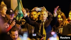 Péter Magyar fluturând steagul maghiar la petrecerea de după victoria din alegeri, 12 aprilie 2026.