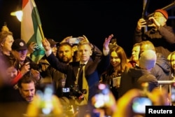 პეტერ მადიარი უნგრეთის დროშას მაღლა სწევს და ზეიმობს მას შემდეგ, რაც უნგრეთის პრემიერ-მინისტრმა ვიქტორ ორბანმა საპარლამენტო არჩევნებში დამარცხება აღიარა.