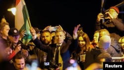 Peter Magyar, vođa opozicione stranke Tisza, drži mađarsku zastavu dok slavi, nakon što je mađarski premijer Viktor Orban priznao poraz na parlamentarnim izborima, u Budimpešti, Mađarska, 12. aprila 2026. 