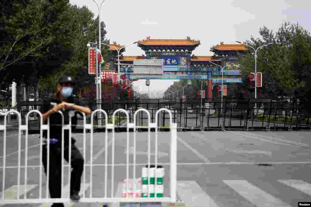 Співробітник служби безпеки в захисній масці біля заблокованого входу на гуртовий ринок Ксінфаді, який був закритий після нового спалаху коронавірусу (COVID-19), в Пекіні, Китай