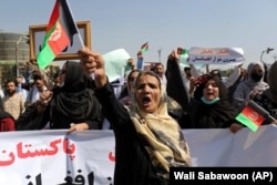 Афганские женщины выкрикивают лозунги и размахивают афганскими национальными флагами во время демонстрации в Кабуле, 7 сентября 2021 года