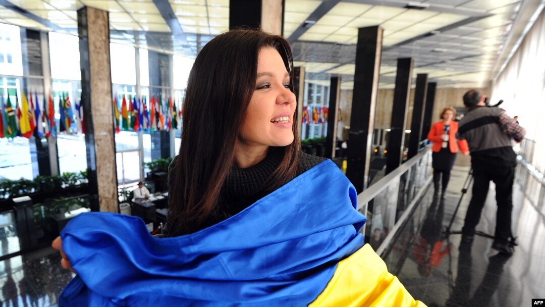 Singer Ruslana Lyzhychko of Ukraine holds a Ukrainian national flag during an interview with AFP at the State Department in Washington in March.