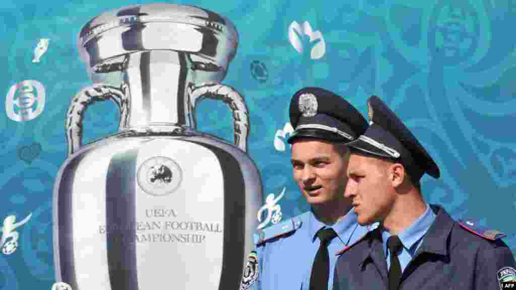 Ukraine -- Police officers walk pass a placard depicting the EURO 2012 tournament cup as they stand guard on Independence Square in Kyiv, 10May2012