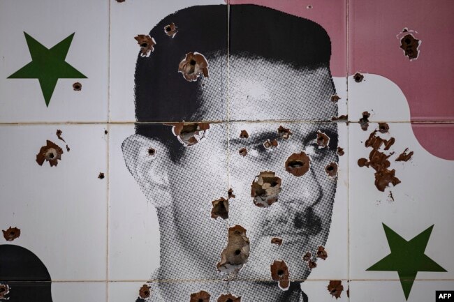 Portreti i presidentit të rrëzuar sirian, Bashar al-Assad, i dëmtuar nga vrimat e plumbave, në një mural në periferi të Damaskut.