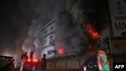 کارکنان اطفائیه در حال مهار آتش در یک مرکز خرید در شهر کراچی در ۱۸ جنوری ۲۰۲۶
