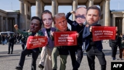 Activiști purtând măști cu chipurile lui Elon Musk, Alice Weidel, Donald Trump, Vladimir Putin și JD Vance în centrul Berlinului, înaintea alegerilor de duminică. „Să facem Rusia măreață din nou”, spune una din pancarte.