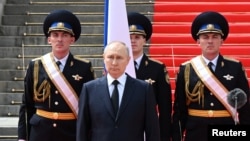 Vladimir Putin stă în fața unor membri ai unităților militare rusești, ai Gărzii Naționale și ai serviciilor de securitate în timpul discursului de omagiere a forțelor armate care au menținut ordinea în timpul revoltei Wagner, în Piața Catedralei de la Kremlin, 27 iunie 2023.