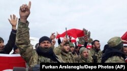 Turkey-backed Free Syrian Army fighters shout slogans before heading towards the Syrian border, in Kirikhan, Turkey, Sunday, Jan. 21, 2018.