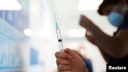 Медайым "Pfizer/BioNtech" вакцинасын эмдөө үчүн даярдоодо. "Поста" борбордук ооруканасы, Сантьяго шаары, Чили. 2020-жылдын 24-декабры.